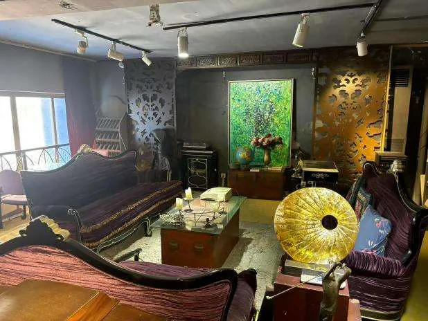 金色唱机、紫色沙发与绘画并置的会客空间
